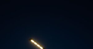Lámpara de alumbrado público encendida contra el cielo nocturno; imagen ilustrativa de archivo.