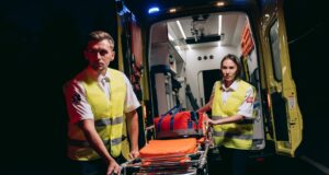 Personal de emergencias prepara una camilla junto a una ambulancia, imagen de archivo