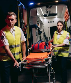 Personal de emergencias prepara una camilla junto a una ambulancia, imagen de archivo