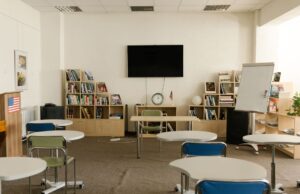Aula vacía con mesas, sillas y pizarra; fotografía de archivo de 2021 alusiva a la suspensión de clases.