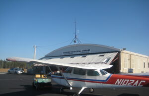 Avionetas de aviación general estacionadas junto a hangares en un aeropuerto