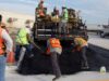 Trabajadores colocan asfalto durante labores de reparación vial; imagen ilustrativa