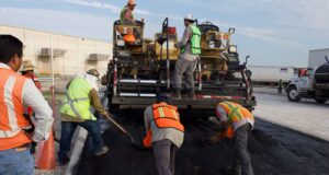 Trabajadores colocan asfalto durante labores de reparación vial; imagen ilustrativa