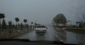 Vehículos circulando por una carretera mojada bajo la lluvia; fotografía de archivo de 2021.