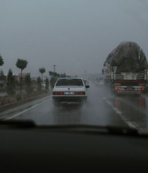 Vehículos circulan por una carretera mojada durante la lluvia; fotografía de archivo.