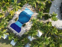 Vista aérea ilustrativa de un complejo turístico con piscina y palmeras en Punta Cana
