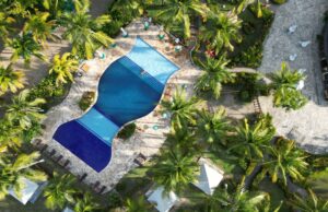 Vista aérea ilustrativa de un complejo turístico con piscina y palmeras en Punta Cana