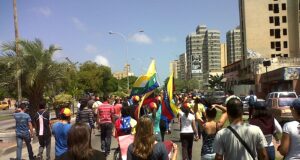 Manifestantes sostienen banderas venezolanas durante una concentración pública