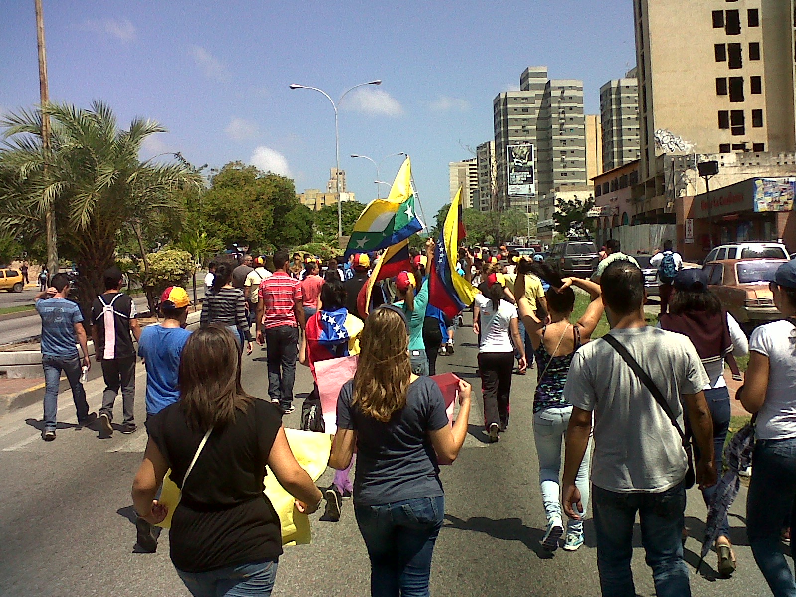 Manifestantes sostienen banderas venezolanas durante una concentración pública