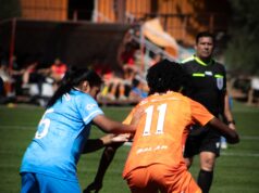Dos futbolistas disputan el balón durante un partido femenino