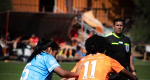 Dos futbolistas disputan el balón durante un partido femenino