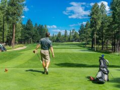 Golfista prepara su golpe desde el tee de salida en un campo de golf.