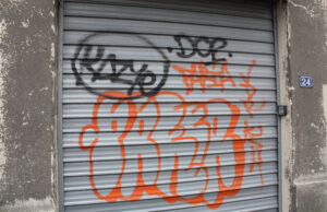Dos personas reparan daños por grafitis en el Bulevar de Higüey Imagen ilustrativa de grafitis sobre una puerta metálica