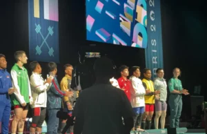Pesistas formados durante una competencia internacional de halterofilia en 2024