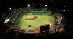Estadio de béisbol iluminado durante un juego nocturno, imagen ilustrativa