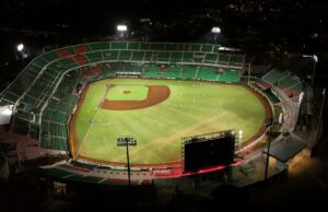 Estadio de béisbol iluminado durante un juego nocturno, imagen ilustrativa