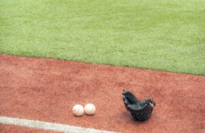 Guante y pelotas de béisbol sobre el terreno de juego