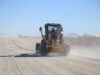 Higüey acondiciona caminos rurales de Naranjo de China Motoniveladora trabajando en un camino de grava en Namibia; imagen ilustrativa de archivo, 2024.