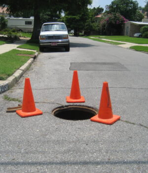 Registro abierto señalizado con conos en Nueva Orleans, junio de 2008; fotografía de archivo de Infrogmation