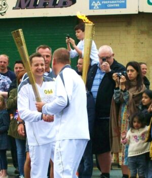 Entrega de una antorcha deportiva durante un relevo ceremonial