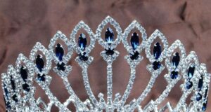 Tiara circular con pedrería azul usada como imagen ilustrativa de un certamen de belleza