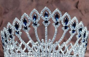 Tiara circular con pedrería azul usada como imagen ilustrativa de un certamen de belleza