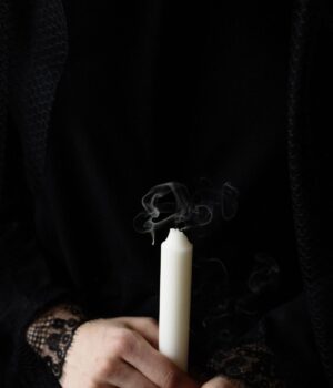 Vela como símbolo de condolencias — archivo, 2021 Manos sostienen una vela blanca apagada, imagen de archivo alusiva al duelo.